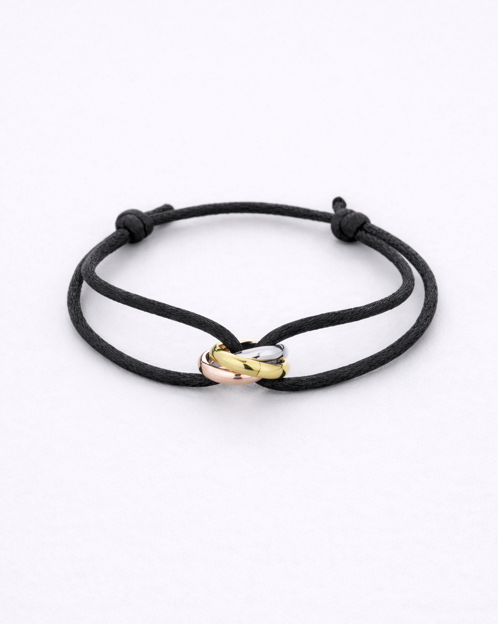 Black cord bracelet with gold and rose gold heart-shaped clasps on a white background