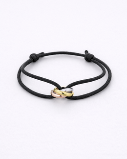 Black cord bracelet with gold and rose gold heart-shaped clasps on a white background